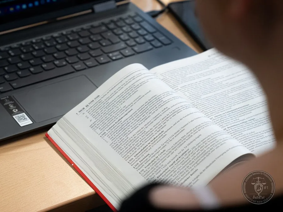 Ein Buch wurde aufgeschlagen, in welchem Paragraphen und Gesetzestexte stehen.