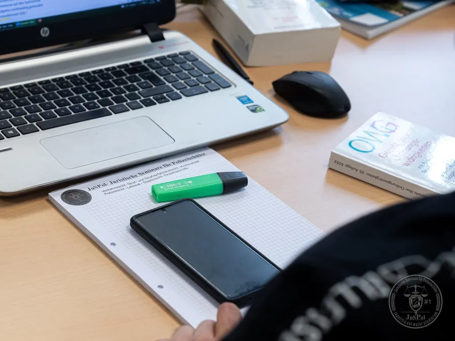 Laptop, Notizbuch, Telefon, Textmarker und Buch auf Schreibtisch