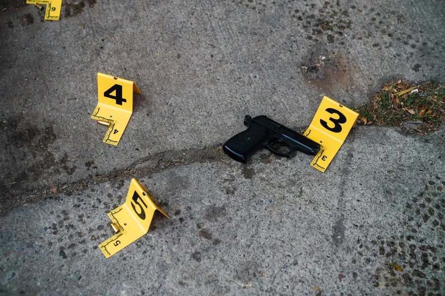 Markierungen für Waffen und Beweismittel an einem Tatort auf Beton
